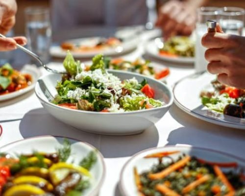 Couple  Eating Lunch with Fresh Salad and Appetizers